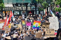 a group of people holding signs and banners in a city
